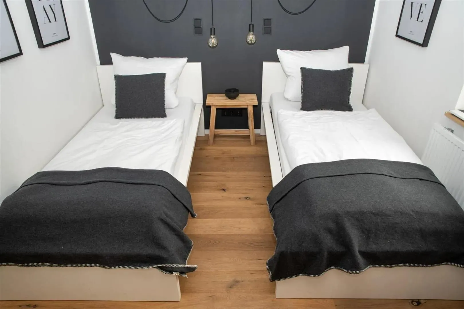 Zimmer mit zwei Einzelbetten und warmem Holzboden